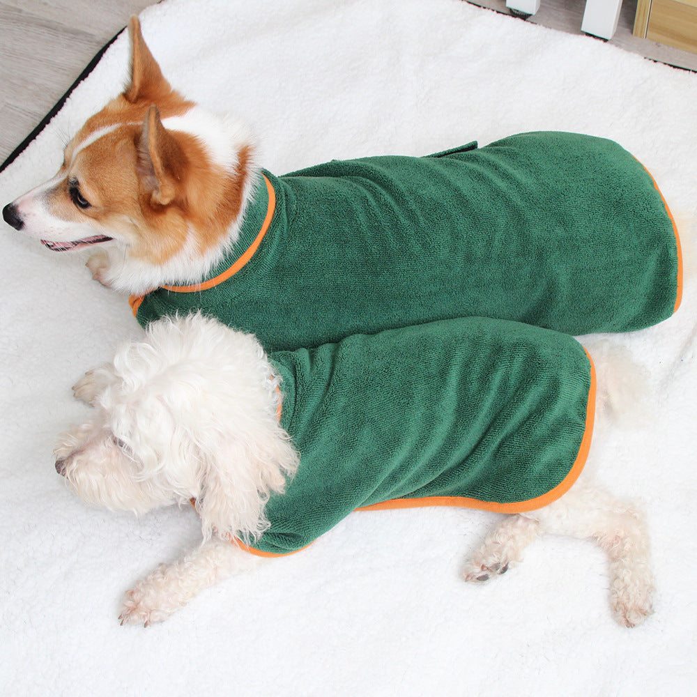 Small dog wearing the green bathrobe on a bed