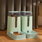 Green gravity feeder and waterer on a wooden floor