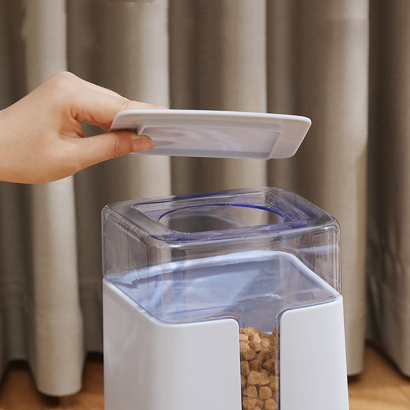 Hand lifting the clear lid off the hopper