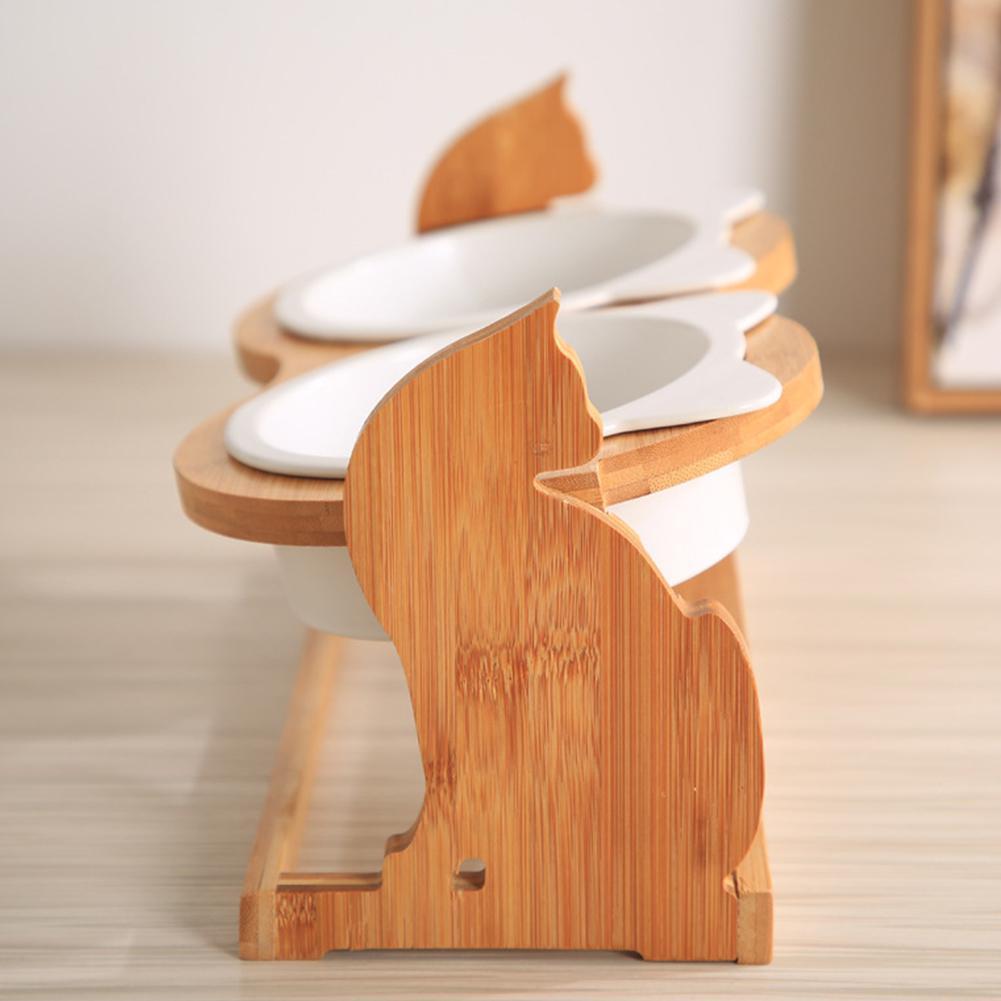 Cat-shaped wooden stand holding two tilted bowls