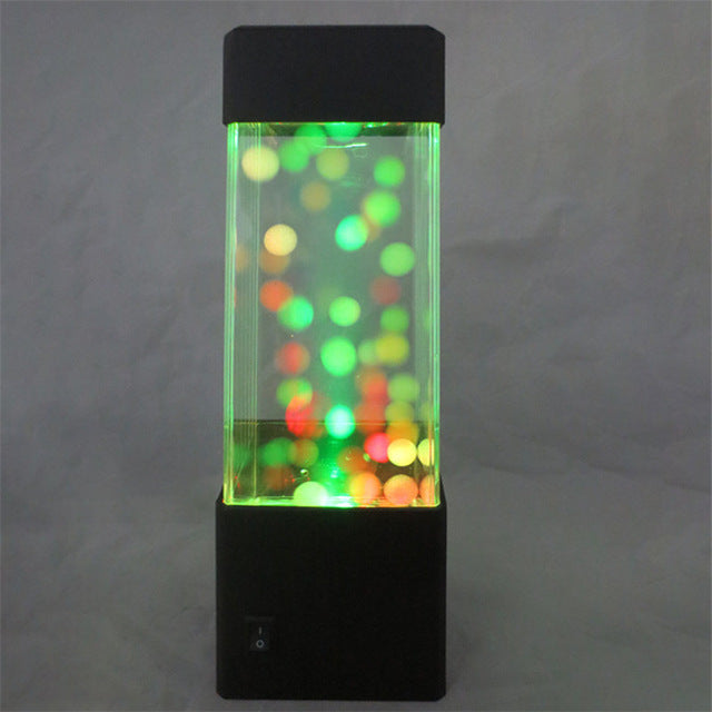 Lamp filled with yellow and red beads on a grey background