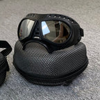 Brown lens goggles resting on the black mesh carry case