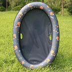 Grey float with an orange patterned rim on grass