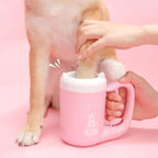 Hand washing a dog's paw inside the pink cup