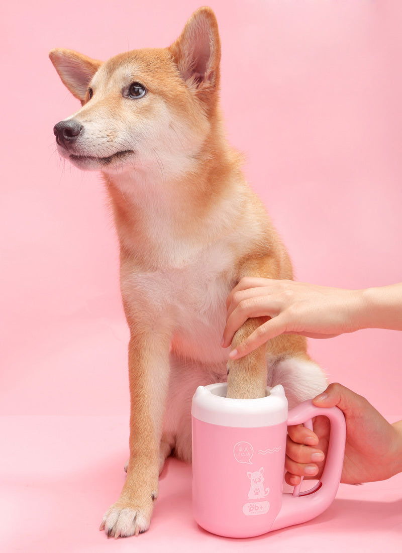Shiba inu having its paw washed in the pink cup