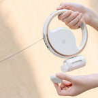 Hands holding the white ring leash with its bottle attachment