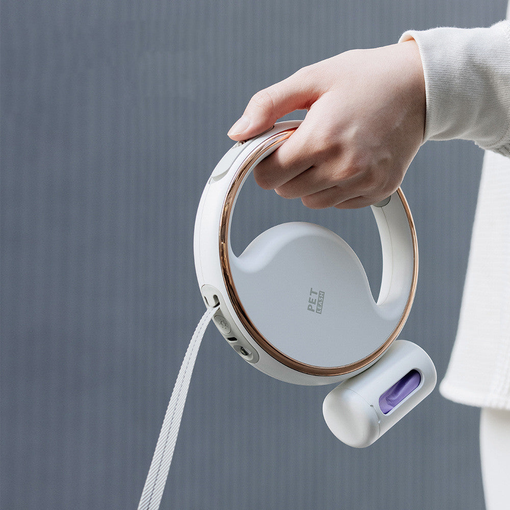 Hand holding the white ring leash with the bottle clipped on