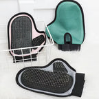 Three gloves in green, pink and grey on a drying rack